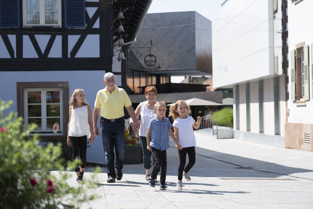 Grands-parents et enfants marchant dans village ensoleillé