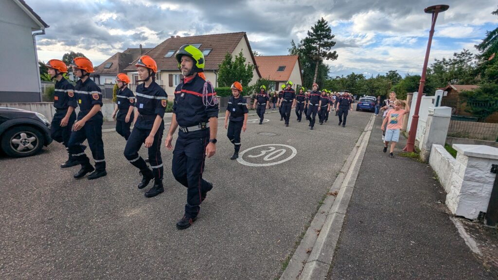 Pompiers défilant dans une rue résidentielle