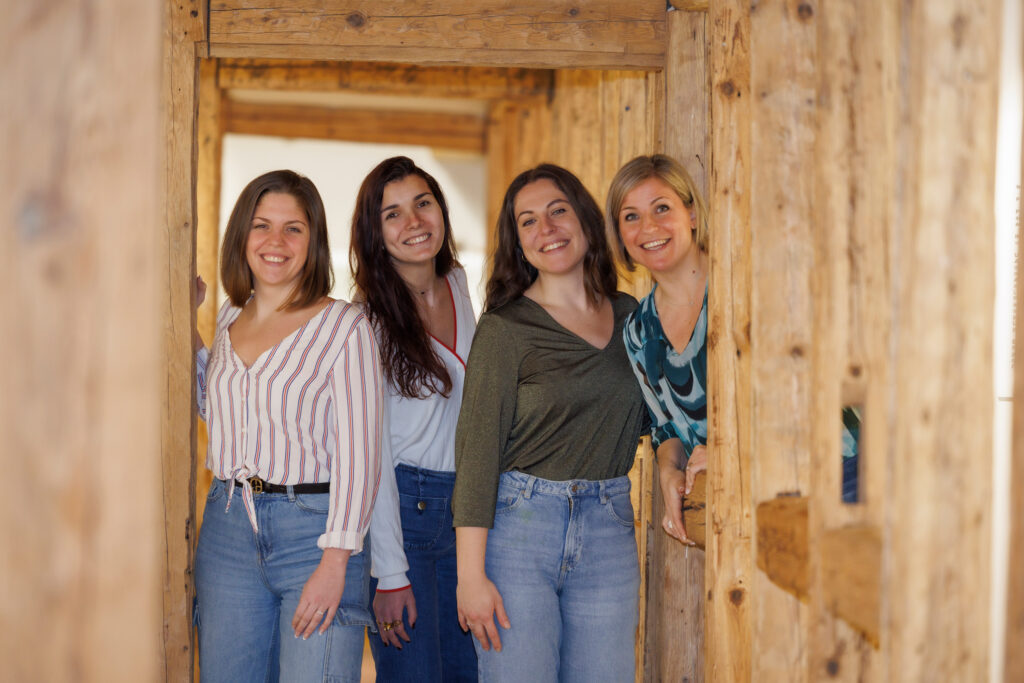 Quatre femmes souriantes dans un intérieur en bois