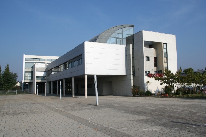Bâtiment moderne blanc avec grande cour pavée