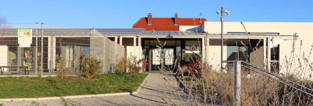 Entrée d’un bâtiment scolaire moderne avec jardin