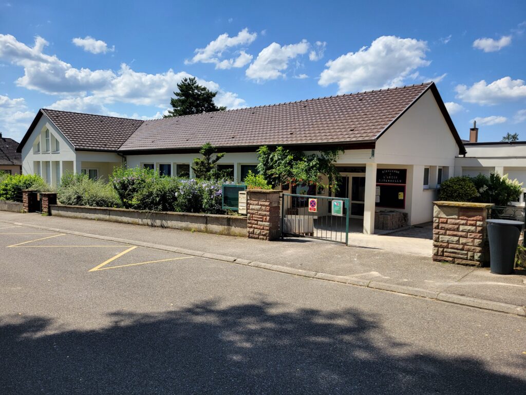 Entrée d’une école maternelle sous ciel bleu
