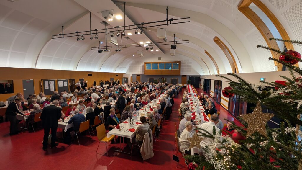 Repas festif dans grande salle décorée pour Noël - Soirée des ainés 2025