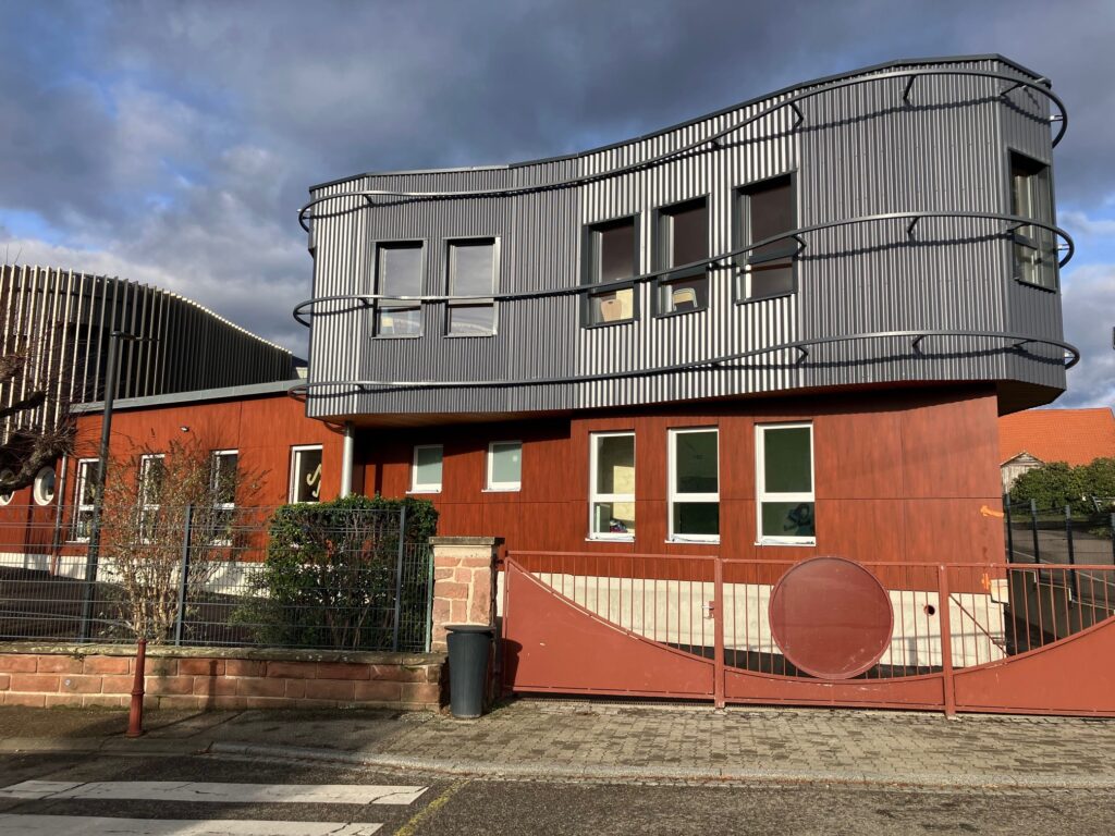 Bâtiment moderne à façade métallique ondulée et bois