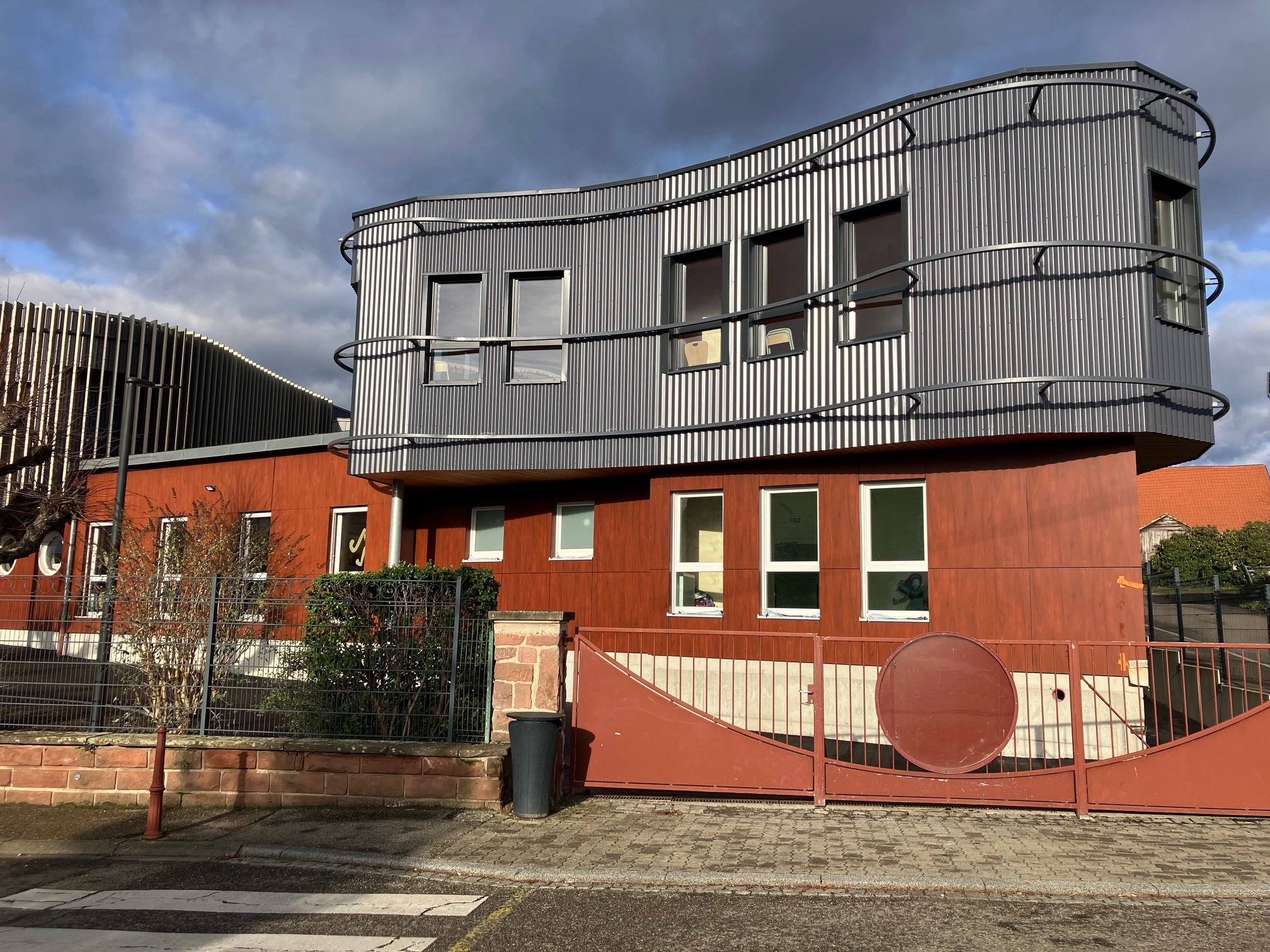 Bâtiment moderne à façade métallique ondulée et bois