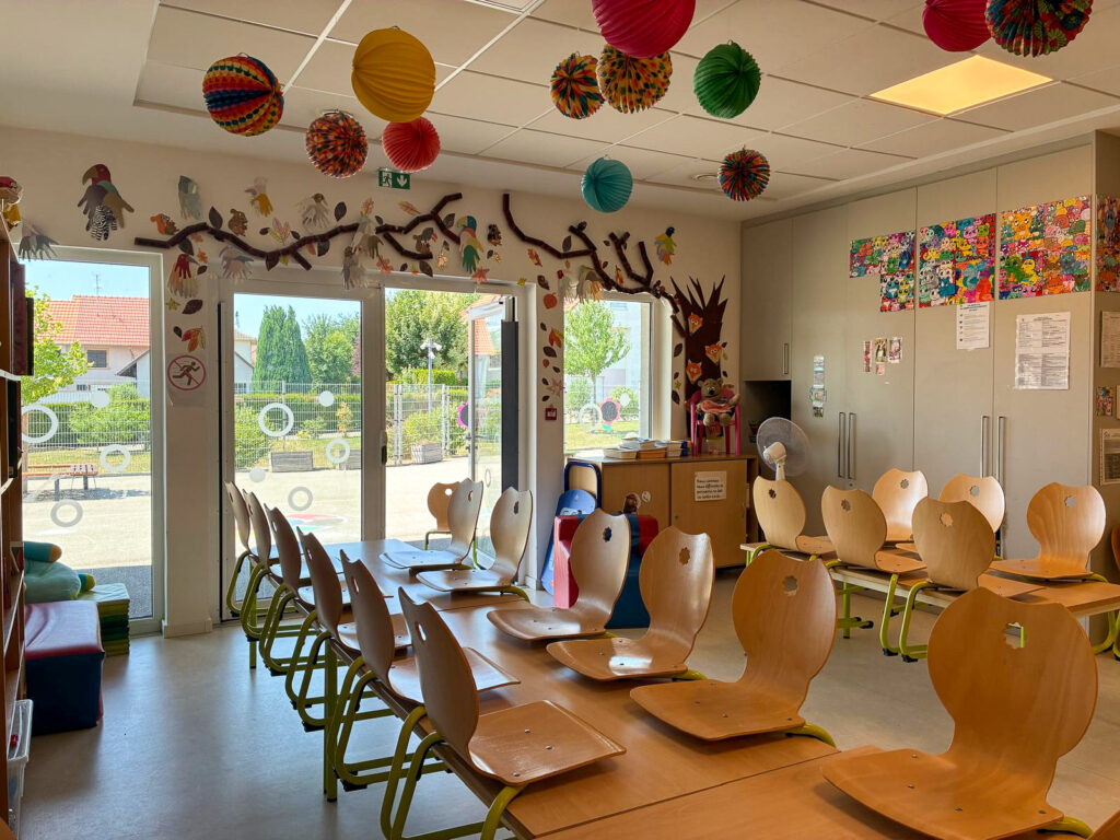 Réfectoire scolaire avec petites chaises et décorations suspendues