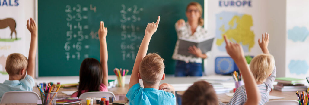 Élèves levant la main en classe de mathématiques