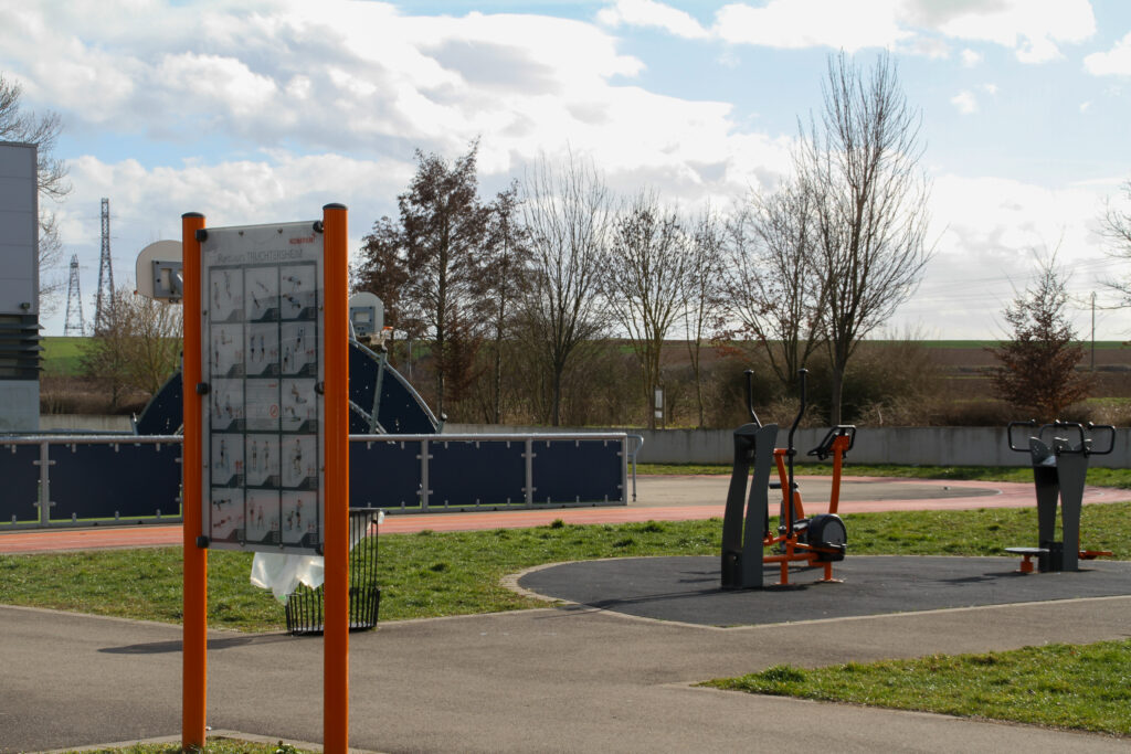Espace fitness extérieur avec machines et panneau d’exercices