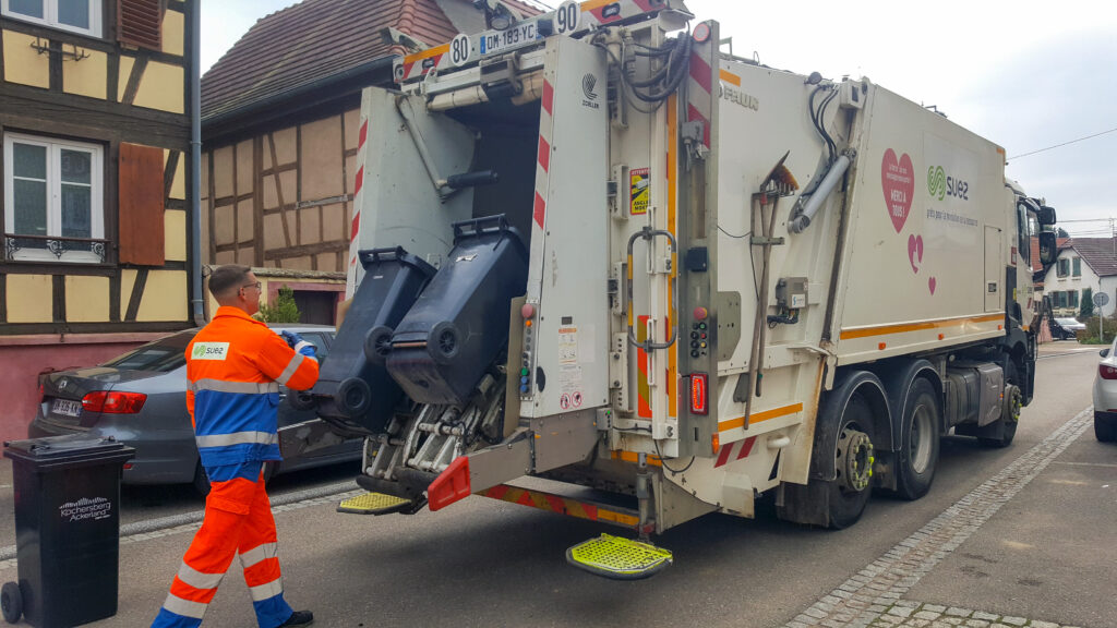 Agent de collecte vidant des bacs d'ordures ménagères dans un camion poubelle