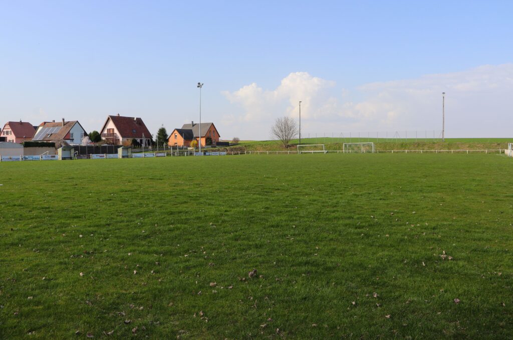 Terrain de football verdoyant à proximité de maisons à Pfettisheim
