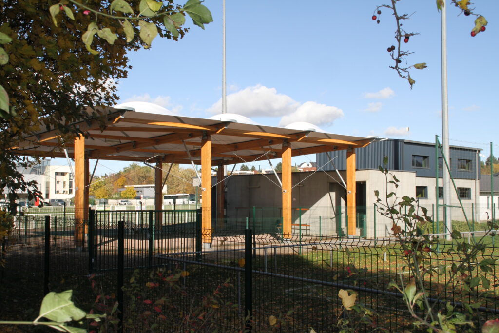 Préau moderne en bois dans cour extérieure