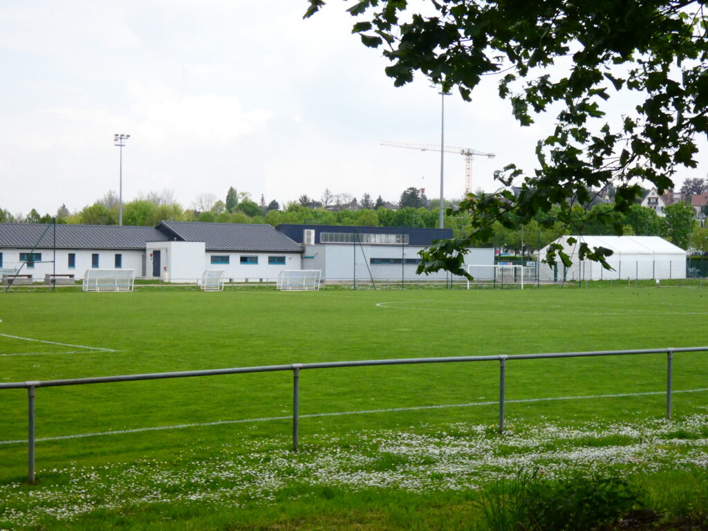 Terrain de football vert et bâtiments sportifs